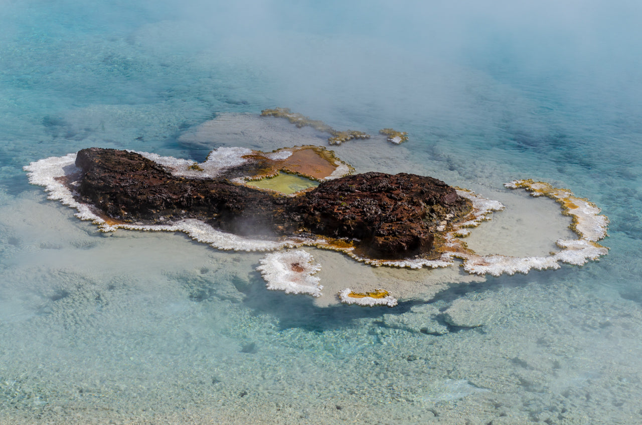 A fine art print of a colored bacteria resembling an island near the grand prismatic hot spring in Yellowstone National Park - landscape photography by Andrew Mease